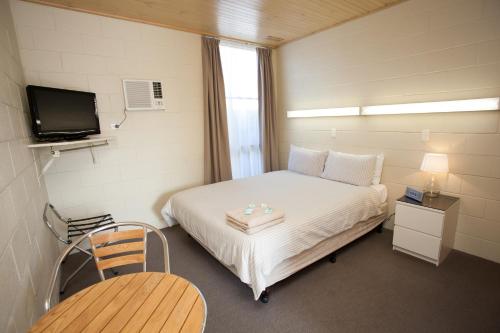 a small room with a bed and a television at Corio Bay Motel in Corio