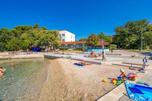 a group of people on the beach at a water park at Apartments and rooms with parking space Sveti Vid, Krk - 5323 in Sveti Vid-Miholjice