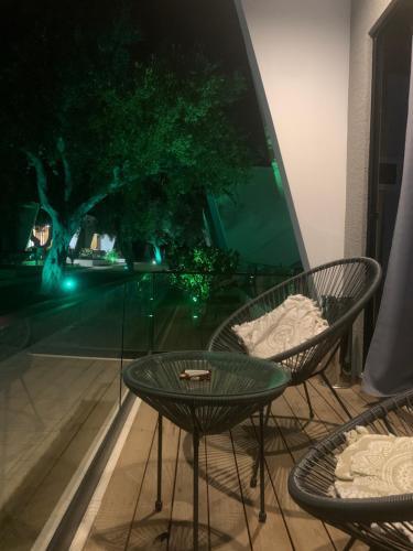 a glass table and chairs on a balcony at night at Luna Mare Boutique Seaside in Borsh