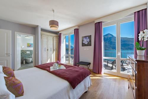 Un dormitorio con una cama grande con una ventana grande. en Villa L'angelo Del Lario, en Carlazzo