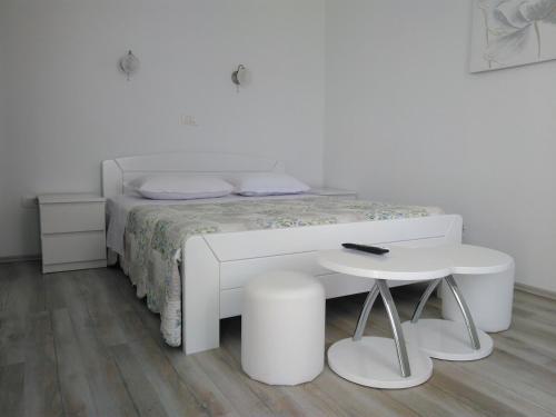 ein weißes Schlafzimmer mit einem weißen Bett und einem Tisch in der Unterkunft Rooms with WiFi Vis - 8905 in Vis