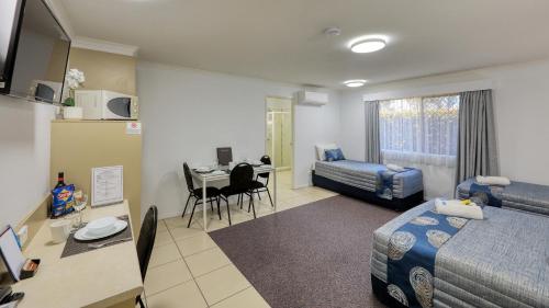 Pokój hotelowy z sypialnią z łóżkiem i biurkiem w obiekcie Chinchilla White Gums Motor Inn w mieście Chinchilla