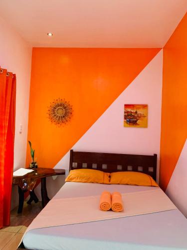 a bedroom with a bed with two slippers on it at Pisces Tourist Inn - Port Barton in San Vicente