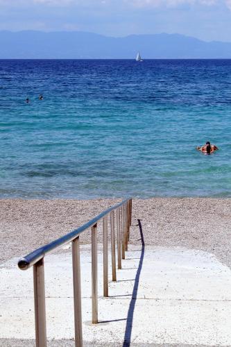 a staircase leading to the beach with people in the water at Apartment Njivice 5458f in Njivice