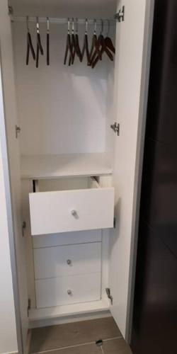 a white closet with a white dresser and hangers at QUIET HOME with private beach in Boracay