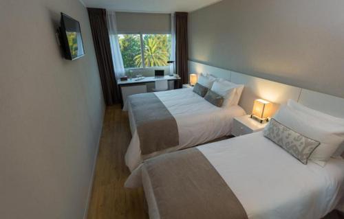 Habitación de hotel con 2 camas y ventana en Gran Hotel Flores en Trinidad