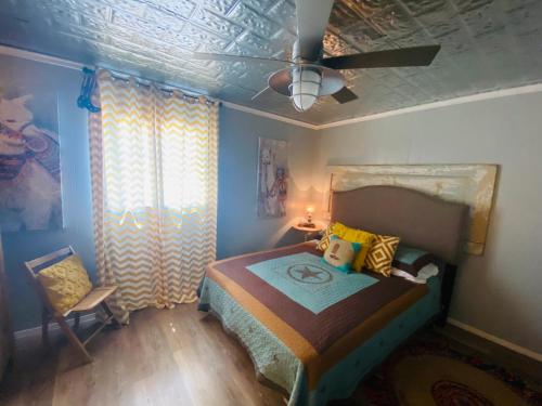 a bedroom with a bed and a ceiling fan at Pecan St. Parlor Haus Downtown Bandera, TX in Bandera