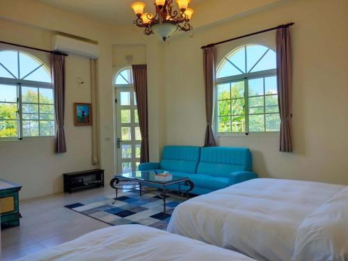 un soggiorno con letto e divano blu di 谷築石苑 a Fengli