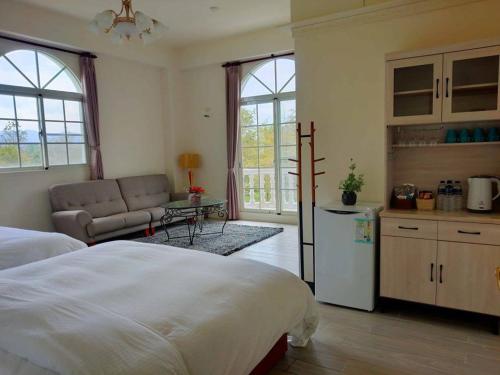 una camera con letto e una cucina con divano di 谷築石苑 a Fengli