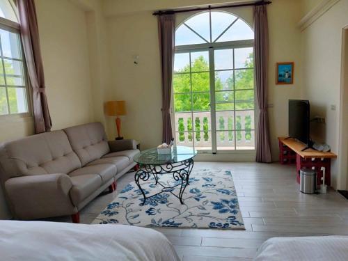a living room with a couch and a table at 谷築石苑 in Fengli