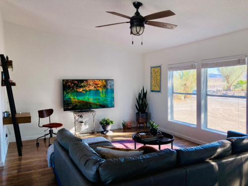 sala de estar con sofá y TV de pantalla plana en Death Valley Hot Springs 3 Bedroom, en Tecopa