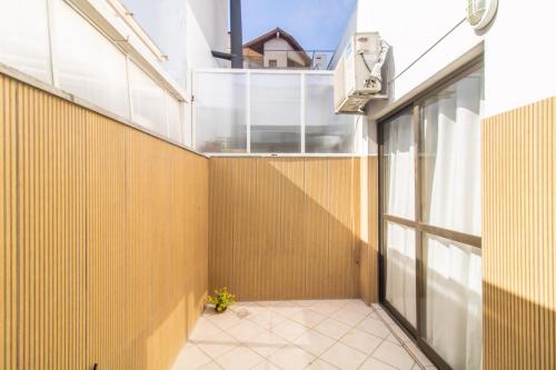 uma varanda com uma porta de vidro e uma planta em Apartamento Moderno com Terraço à 4Km do Consulado USA em Porto Alegre