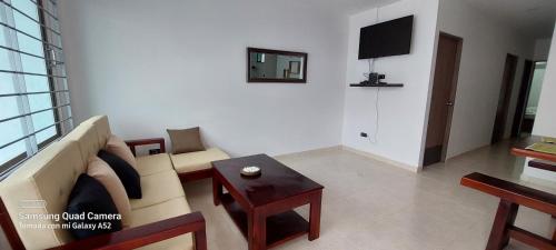 uma sala de estar com um sofá e uma mesa em Cabaña la Isla-Coveñas em Coveñas