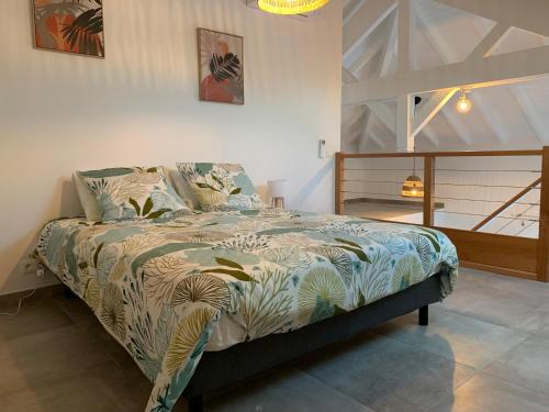 a bedroom with a bed with a comforter on it at Duplex Cosy au cœur de Marigot in Marigot