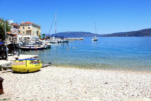 a beach with boats and ducks in the water at Apartments by the sea Valun, Cres - 8081 in Valun