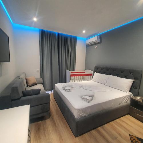 a bedroom with a large bed and a couch at Villa Mehmeti in Sarandë