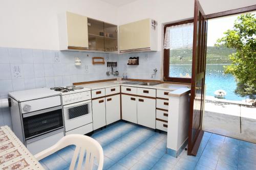 a kitchen with white appliances and a large window at Apartments by the sea Kabli, Peljesac - 10225 in Brijesta