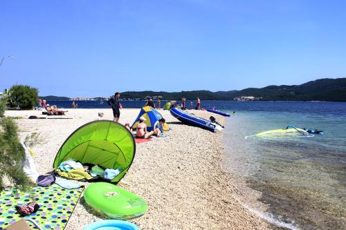 a beach with a group of people on the water at Apartments with parking space Viganj, Peljesac - 10188 in Viganj