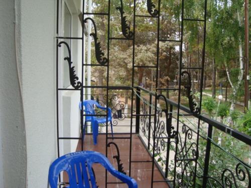 a balcony with two chairs and a view of a yard at Guest House at DO Altyn - Kum in Chon-Sary-Oy