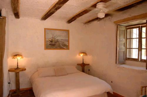 Ladera Loft Pisco Elqui في بيسكو إلكي: غرفة نوم بسرير ابيض ومصباحين