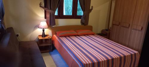a bedroom with a bed with a lamp and a window at Galagoda Walawwa in Rambukkana