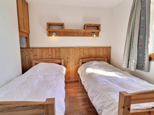 deux lits dans une chambre aux murs en bois dans l'établissement Appartement cosy à La Tania - 2 Pièces, 4 pers, skis aux pieds, proche centre et remontées mécaniques - FR-1-182A-3, à Courchevel