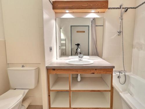 une salle de bain avec un lavabo, des toilettes et un miroir dans l'établissement Appartement cosy à La Tania - 2 Pièces, 4 pers, skis aux pieds, proche centre et remontées mécaniques - FR-1-182A-3, à Courchevel