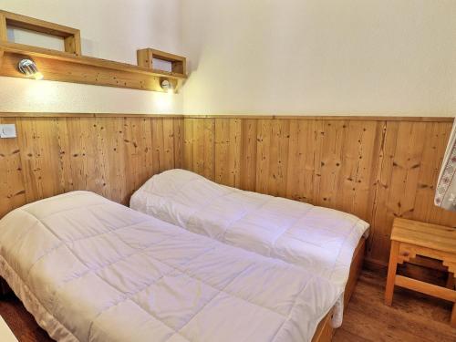1 dormitorio con 2 camas y pared de madera en Appartement La Tania, 2 pièces, 4 personnes - FR-1-182A-13 en Courchevel