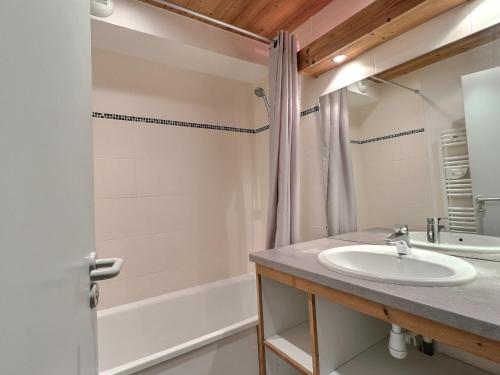 een badkamer met een wastafel en een bad bij Appartement La Tania, 2 pièces, 4 personnes - FR-1-182A-27 in Courchevel