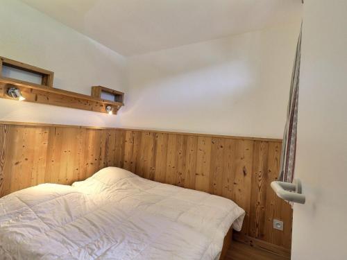 um quarto com paredes de madeira e uma cama num quarto em Appartement La Tania, 2 pièces, 4 personnes - FR-1-182A-31 em Courchevel