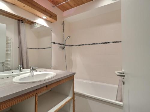 uma casa de banho com um lavatório e uma banheira em Appartement La Tania, 2 pièces, 4 personnes - FR-1-182A-31 em Courchevel