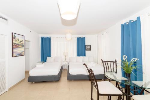 um quarto com duas camas e uma mesa e cadeiras em Apartments on Ocean Drive em Miami Beach
