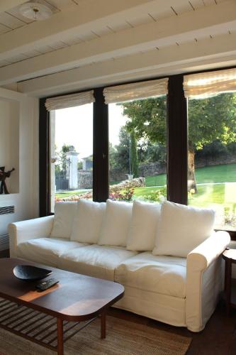 sala de estar con sofá blanco y ventanas grandes en Villa Trieste M, en Asolo