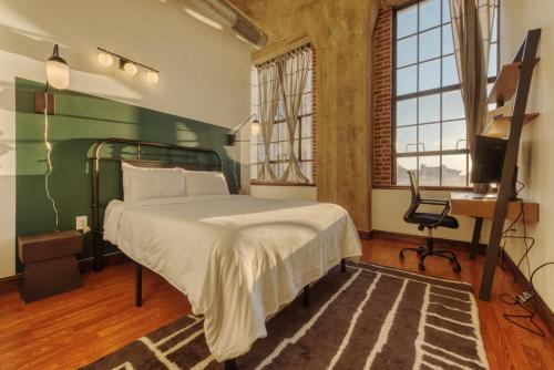 Dormitorio con cama, escritorio y TV en Sosuite at Independence Lofts - Callowhill, en Filadelfia