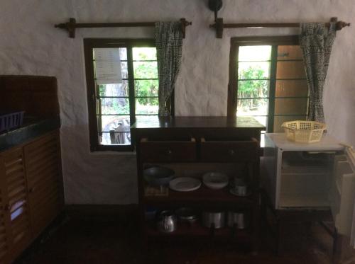 a kitchen with two windows and a counter top at Diani Banda Cottages in Diani Beach