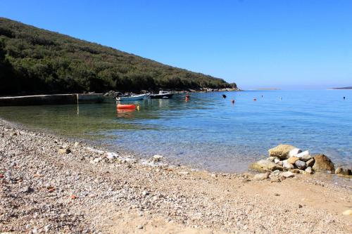 a rocky beach with boats in the water at Apartment Stivan 382c in Štivan