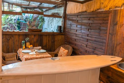 un comedor con mesa y sillas y una habitación con ventana en Douceur Tropicale Proximité plage et commerces en Punaauia
