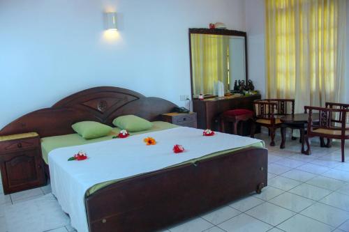 a bedroom with a large bed with flowers on it at Villa Ranmenika in Ahungalla