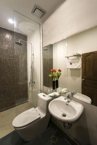 a bathroom with a toilet and a sink and a shower at White Residence Hotel & Apartment in Phnom Penh
