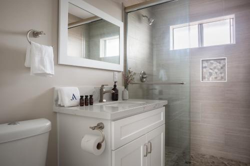 a white bathroom with a sink and a shower at Seashore IV by AvantStay Comfortable La Jolla Flat 5mins from the Beach in San Diego