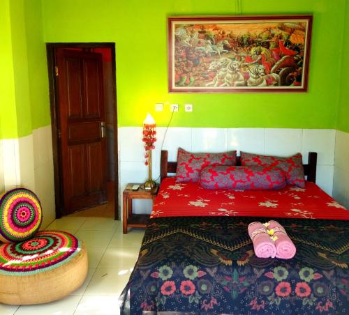 ein Schlafzimmer mit einem Bett und einem Wandgemälde in der Unterkunft Pelangi Beach Homestay in Amed
