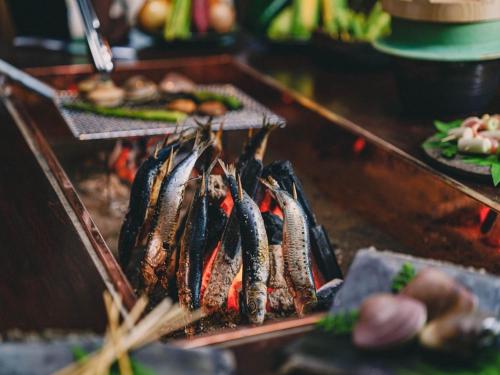a bunch of seafood on a grill in a restaurant at Kominkayado LOOF Okanoie in Yamanashi