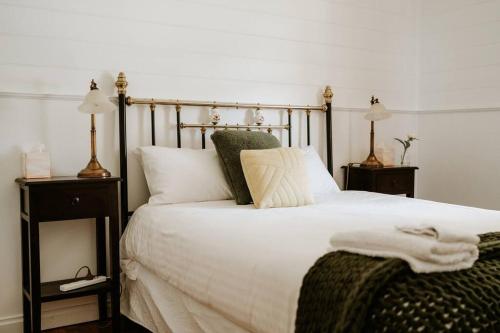 a bedroom with a large bed with white sheets and pillows at Cottage on Gray - Wangaratta in Wangaratta
