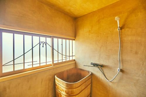 una vasca da bagno in una stanza con finestra di 古民家宿るうふ 丘之家 Okanoie a Yamanashi