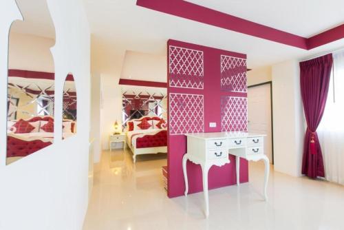 a bedroom with two beds and a table in it at Harmonize Hotel Chiang Mai in Chiang Mai