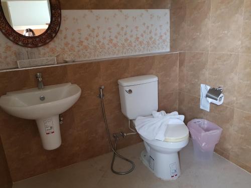 a bathroom with a toilet and a sink and a mirror at Harmonize Hotel Chiang Mai in Chiang Mai