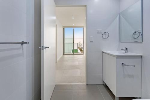 bagno bianco con doccia e lavandino di KULA Sydney Airport a Sydney