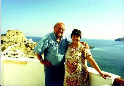 a man and a woman standing next to the ocean at Arhontiko Hotel in Foinikion