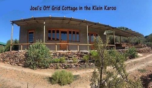 a building in the middle of a field at Joel's Off Grid Cottage in the Klein Karoo in Oudtshoorn