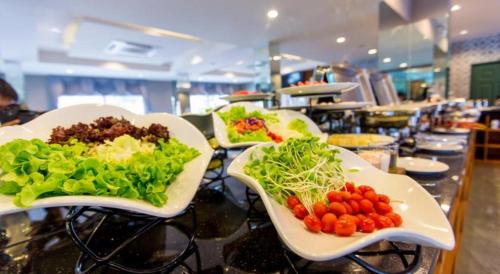 three plates of food on a table in a restaurant at Harmonize Hotel Chiang Mai in Chiang Mai